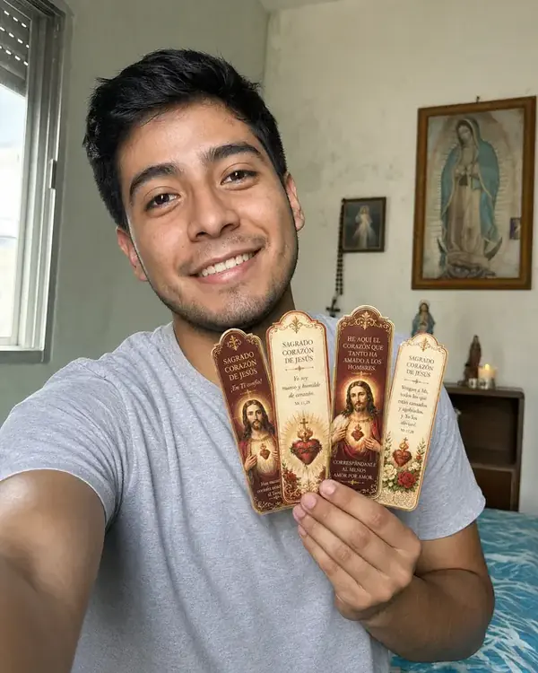 Cliente sosteniendo cuatro marcapáginas del Sagrado Corazón de Jesús